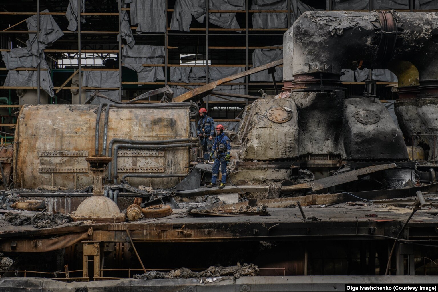 Punonjësit e urgjencës kalojnë nëpër termocentralin e dëmtuar rëndë të Harkivit pasi u godit nga një raketë ruse në mars.