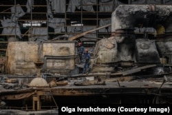 Radnici hitne pomoći obilaze teško oštećenu termoelektranu u Harkivu nakon što ju je u martu pogodila ruska raketa.