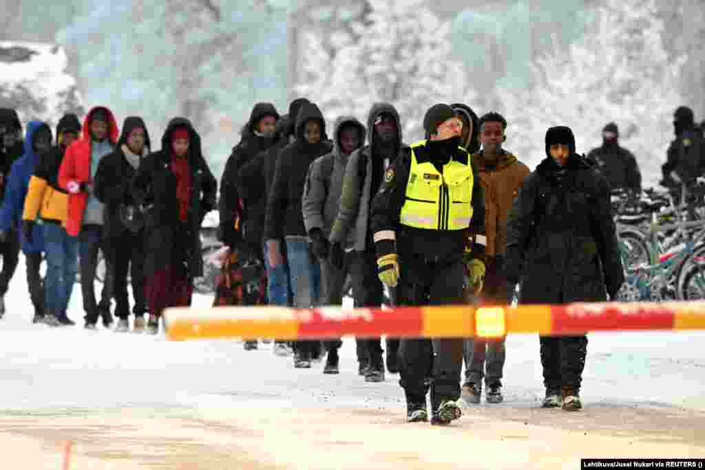 Finski graničari prate migrante na graničnom prelazu u Sali, na severu Finske, 23. novembra. Finski premijer Peteri Orpo optužio je Moskvu da stoji iza neuobičajeno velikog povećanja broja tražilaca azila koji ulaze u Finsku.