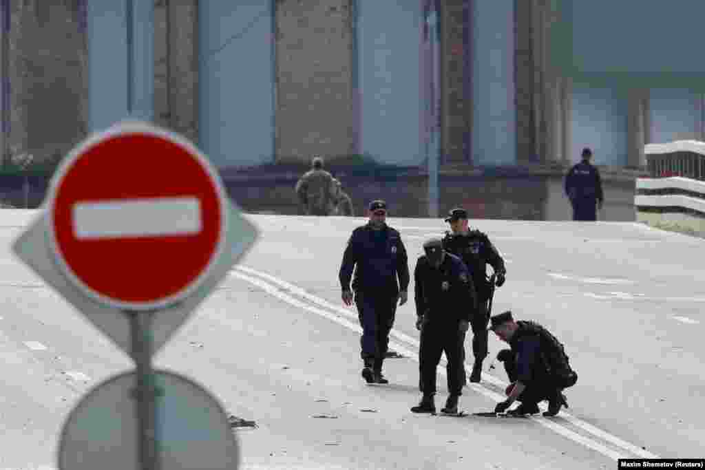 Members of the security services investigate a bridge near the site of a damaged building in Moscow. Moscow Mayor Sergei Sobyanin said the drone strikes occurred around 4 a.m. local time.&nbsp;