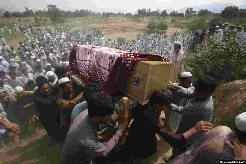 Relatives and mourners carry the casket of a victim killed in the July 30 suicide bomb attack in the Bajaur district of Khyber Pakhtunkhwa Province, Pakistan. The Islamic State-Khorasan (IS-K) extremist group claimed responsibility for the attack, which killed at least 54 people and wounded 100 at a political rally.