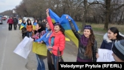 Молоді кримчанки у кримськотатарських національних уборах та з українськими прапорами протестують проти проведення псевдореферендуму в Криму. Околиці Сімферополя, Крим, 14 березня 2014 року