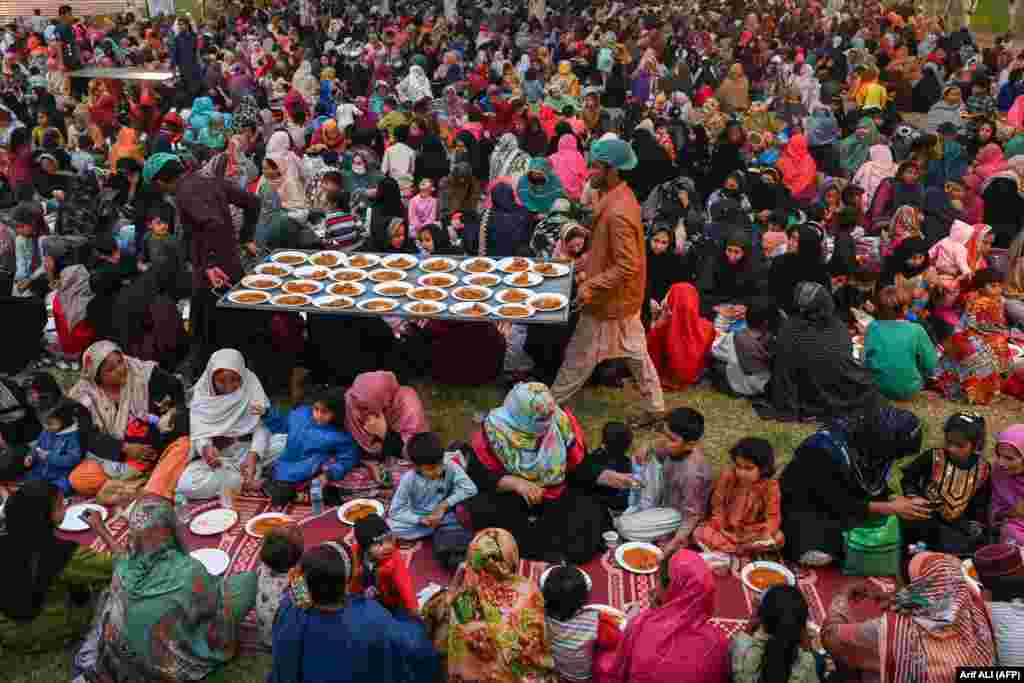 Volunteers distribute free food as Muslim devotees gather to break their fast during the Islamic holy month of Ramadan in Lahore, Pakistan.