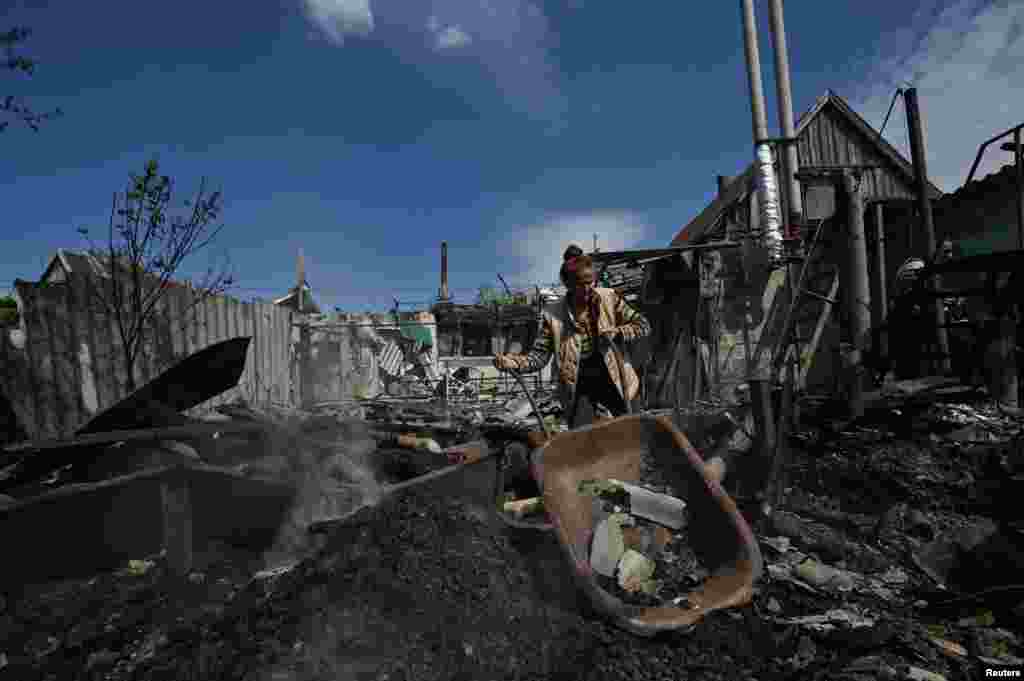 A&nbsp; woman removes debris of a residential house destroyed by a Russian military strike in the village of Malokaterynivka, Zaporizhzhya region.