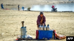 An Afghan tea vendor looks for customers along the shrunken Qargha Reservoir on the outskirts of Kabul on January 18.