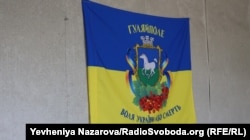 Один з прапорів у прифронтовій зоні, Гуляйполе, Запорізька область, травень 2023 року. На прапорі напис: «Воля України або смерть». Також зображено герб Гуляйполя