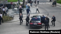 Gărzile de corp ale premierului slovac Robert Fico l-au luat pe sus și l-au urcat în autoturism după atac. În același timp, poliția l-a imobilizat pe cel care l-a atacat - Handlová, Slovacia, 15 mai 2024.
