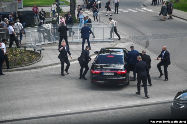 Zyrtarë të sigurimit duke e futur kryeministrin sllovak Roberto Fico në një veturë, pasi ai u plagos. 15 maj 2024.