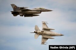 Истребители F-16 румынских ВВС пролетают над военной авиабазой недалеко от города Фетешти, где открыт международный тренировочный центр для обучения украинских пилотов на самолетах F-16. Румыния, 13 ноября 2023 года