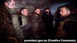 Ukrainian President Volodymyr Zelenskiy (tight) talks to soldiers at military positions near the front line in Robotyne on February 4.