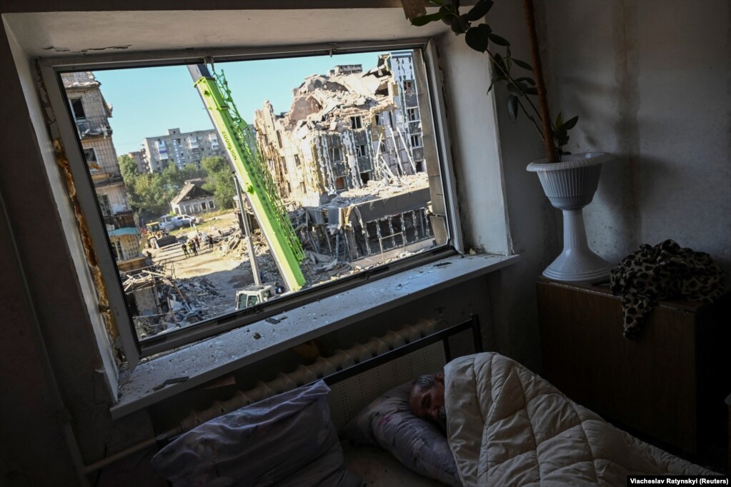 Një banor vendas duek fjetur në banesën e tij në një ndërtesë apartamentesh të dëmtuara gjatë një sulmi rus me raketa në Pokrovsk, Ukrainë.
