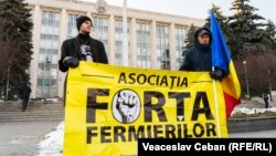 Protestatari ținând un banner al asociației „Forța Fermierilor”, în timpul manifestațiilor din fața Guvernului.