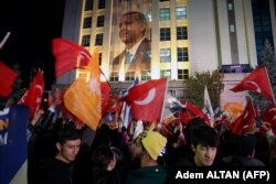 Сторонники президента Турции Тайипа Эрдогана размахивают флагами возле штаб-квартиры ПСР после закрытия избирательных участков на президентских и парламентских выборах в Турции в Анкаре, Турция, 15 мая 2023 года