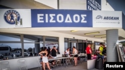 Turisti na Rodosu ispred sportske dvorane u koju su smješteni nakon evakuacije, 23. juli 2023. 