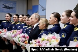 Президент России Владимир Путин позирует для фото с выпускницами Высшей военной авиационной школы летчиков в Краснодаре, 7 марта 2024 года