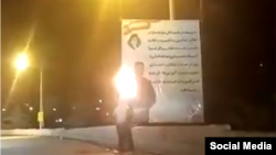 A screen grab from a video published on social media showing protesters setting fire to government propaganda banners in the southwestern Iranian city of Yasuj on February 20. 