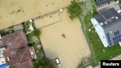 Жителите користат чамец за да се движат низ надојдената вода откако обилните дождови го погодија италијанскиот регион Емилија Ромања, Италија, 18 мај 2023 година.