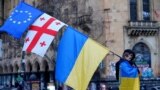 A demonstrator carries an EU flag with the Georgian and Ukrainian ones during a rally marking two years since Russia's full-scale invasion of Ukraine in Tbilisi on February 24.