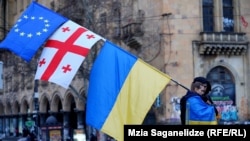 A demonstrator carries an EU flag with the Georgian and Ukrainian ones during a rally marking two years since Russia's full-scale invasion of Ukraine in Tbilisi on February 24.