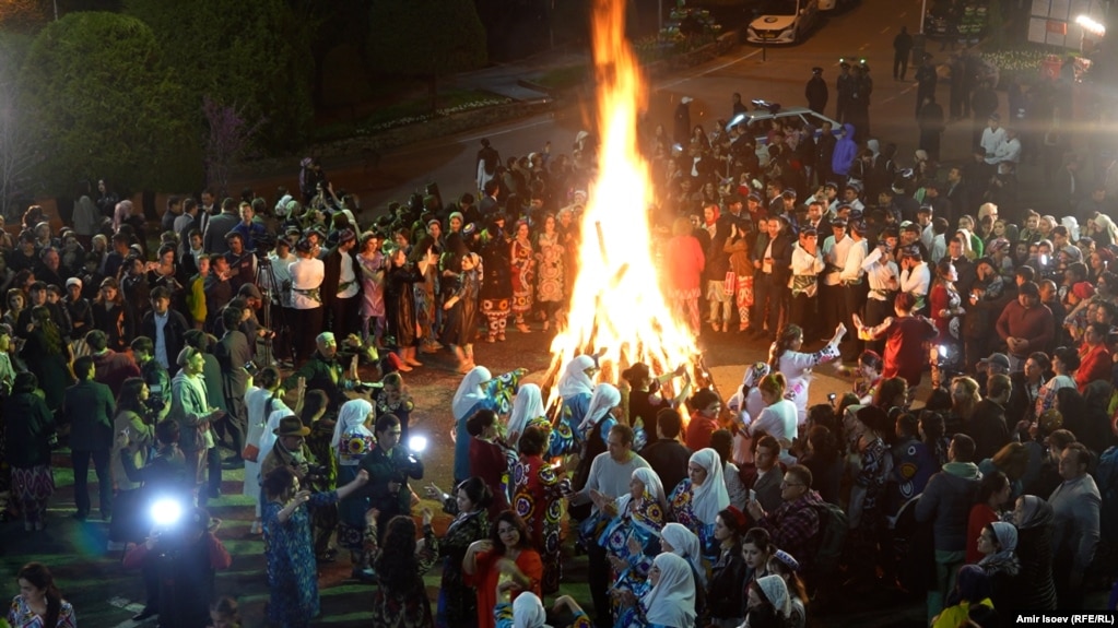 People dance and sing around a large bonfire in Dushanbe.  