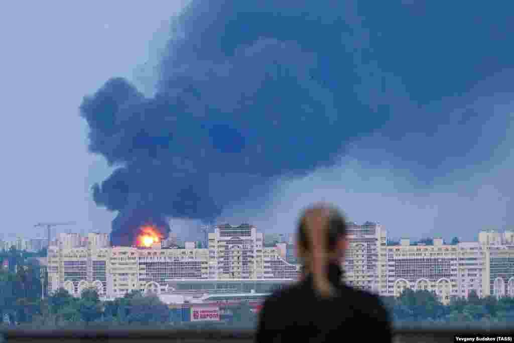 A woman watches a fuel tank burning in Voronezh, southern Russia, on June 24. The fuel tank exploded as a Russian military helicopter flew near it during the short-lived uprising by the Wagner mercenary group.&nbsp;