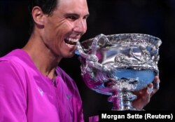 Rafael Nadal i Spanjës kafshon trofeun për të festuar fitoren në finalen e meshkujve teke, Australian Open, Melbourne Park, Melburn, Australi - 31 janar 2022.