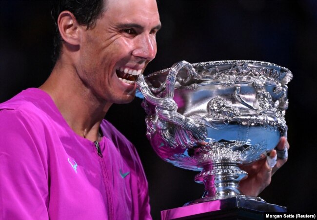 Rafael Nadal i Spanjës kafshon trofeun për të festuar fitoren në finalen e meshkujve teke, Australian Open, Melbourne Park, Melburn, Australi - 31 janar 2022.