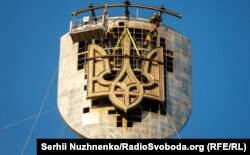 Монтаж герба на щит монумента. Киев, Украина, 6 августа 2023 года