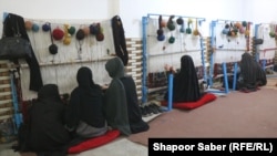 دختران و زنان سرگرم بافتن قالین در یکی از دستگاه های قالین بافی در هرات هستند 