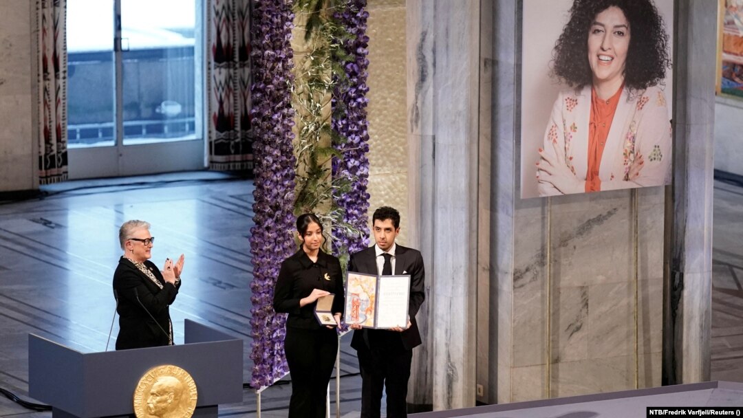 Kiana (center) and Ali Rahmani, Narges Mohammadi's children, accept the Nobel Peace Prize on behalf of their mother (upper right) in Oslo in December 2023.