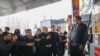 جواد اوجی، وزیر نفت جمهوری اسلامی ایران، در حال گفتگو با یکی از کارکنان یک پمپ بنزین در تهران پس از حمله سایبری روز ۲۷ آذر