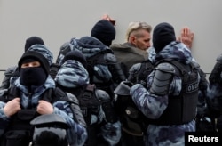  Полицаи задържат мъж наоколо до Борисовското гробище в Москва, където се организира погребението на Навални. 1 март 2024 година 