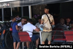 Two young boys beg for money in return for playing music on the streets of Prizren, Kosovo.