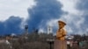 Smoke rises behind a World War II memorial in Donetsk, Russian-controlled Ukraine, on February 19.