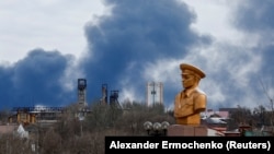 Smoke rises behind a World War II memorial in Donetsk, Russian-controlled Ukraine, on February 19.