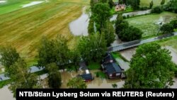 Pogled na kuću djelimično pod vodom u Leni, Norveška, 8. avgusta 2023. Ekstremno vrijeme "Hans" pogodilo je istočnu Norvešku sa jakom kišom, a Meteorološki zavod je izdao crveno upozorenje za veoma jaku kišu, poplave i klizišta na sjeveru 