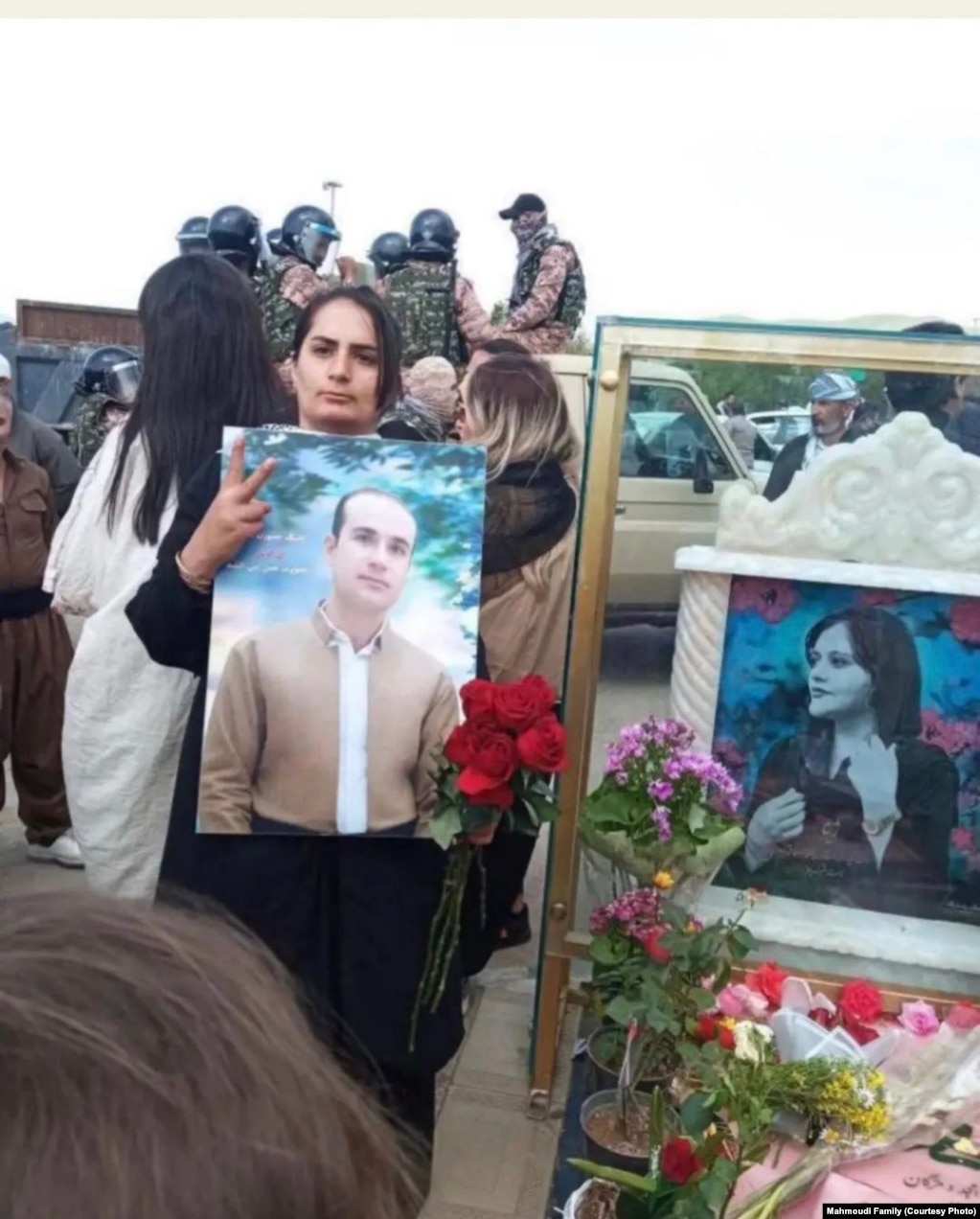 The wife of Fereydoun Mahmoudi, who was one of the victims of the protests in Iran, holds his picture.