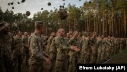 Newly recruited soldiers celebrate the end of their training at a military base close to Kyiv on September 25, 2023.