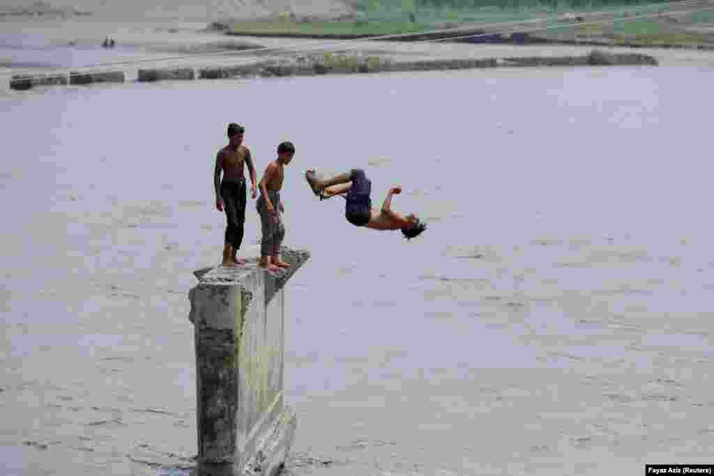 Boys jump into the Naguman River to cool off amid hot weather on the outskirts of Peshawar, Pakistan.