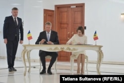 Maia Sandu și Klaus Iohannis, în timp ce semnează declarația comună