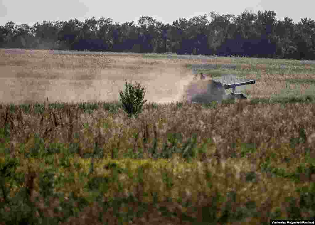 Një obus vetëlëvizës ukrainas M109 duke lëvizur nëpër tokat bujqësore në rajonin e Donjeckut, më 7 gusht. Në rajonin e Zaporizhjas, forcat e Kievit u përplasën me atë që ekspertët e përshkruan si një mulli mishi i fortifikimeve ruse -- shumë llogore, fusha të minuara, tela me gjemba, mbrojtje kundër tankeve, kuti pilulash -- që i detyruan njësitë ukrainase të mblidhen në rripa të ngushtë toke ku u ndëshkuan nga artileria ruse.