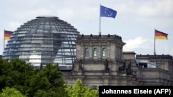 საილუსტრაციო ფოტო. გერმანიის და ევროკავშირის დროშები ბერლინში, ბუნდესტაგის შენობაზე
