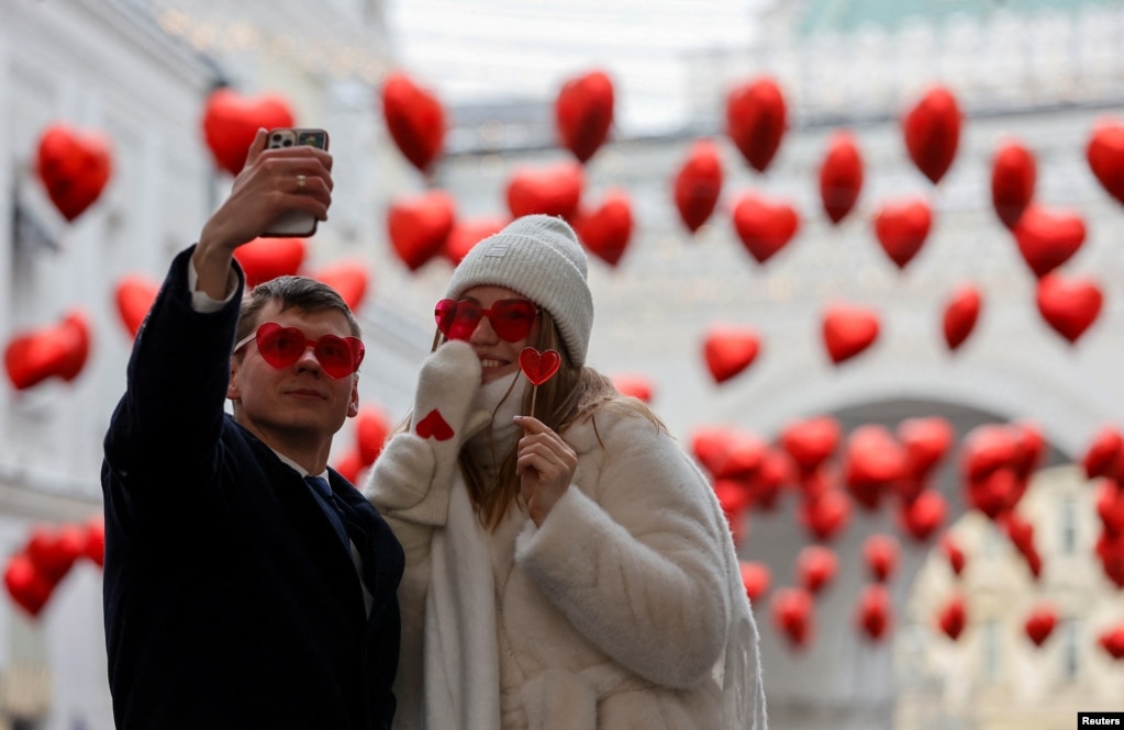 Një çift duke bërë foto selfie në një rrugë të zbukuruar me balona në formë zemrash në Ditën e Shën Valentinit në Moskë, Rusi, më 14 shkurt 2024.