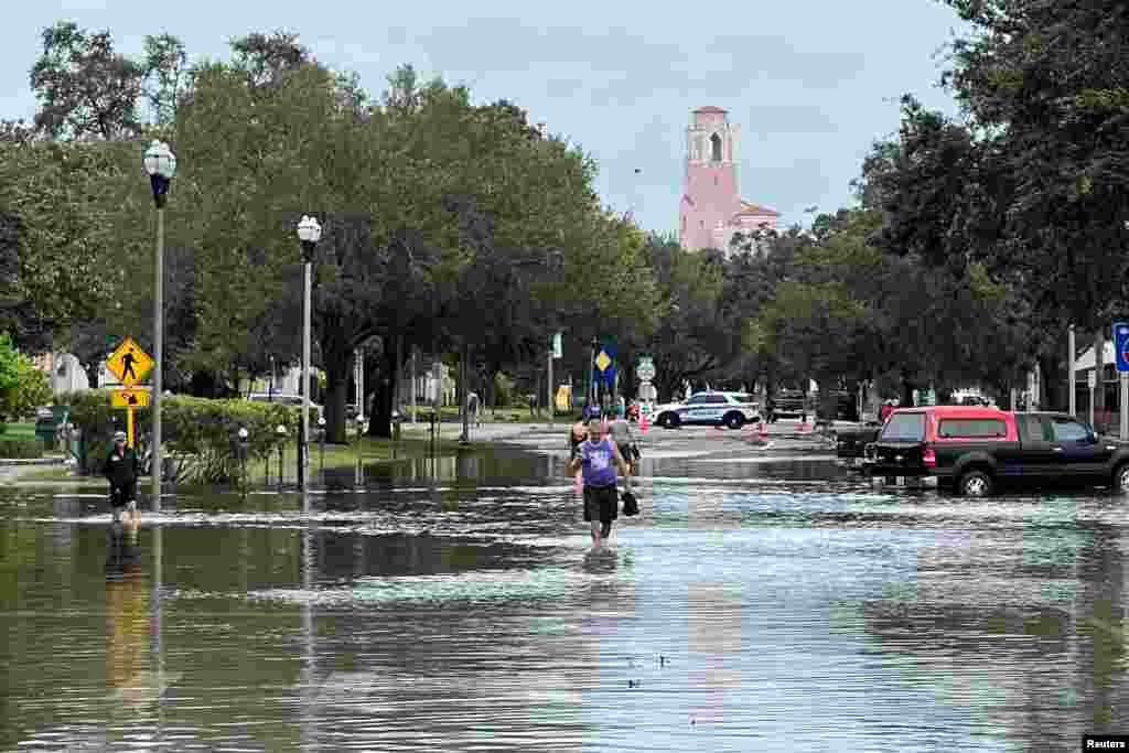 Njerëzit duke ecur nëpër rrugët e përmbytura në Shën Petersburg, Florida, SHBA.&nbsp;