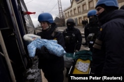 Рятувальник передає дитину матері до евакуаційного потягу, Покровськ, 20 лютого 2024 року