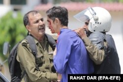 Pakistani Police detain an injured supporter of former Prime Minister Imran Khan during a protest in Lahore last year.