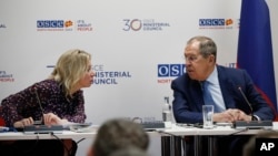 Ministrul de externe al Rusiei, Serghei Lavrov, dreapta, discută cu purtătorul de cuvânt Maria Zaharova la o conferință de presă, în timpul reuniunii Consiliului Ministerial al OSCE, la Skopje, Macedonia de Nord, decembrie 2023.