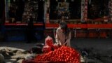 Një shitës afgan duke shitur domate në një rrugë në Kabul.