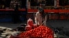 An Afghan street vendor arranges tomatoes for sale in Kabul. 