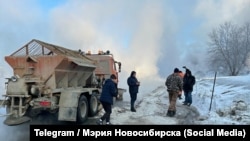 Utility workers tackle the consequences of a burst pipe in Novosibirsk on January 18. 